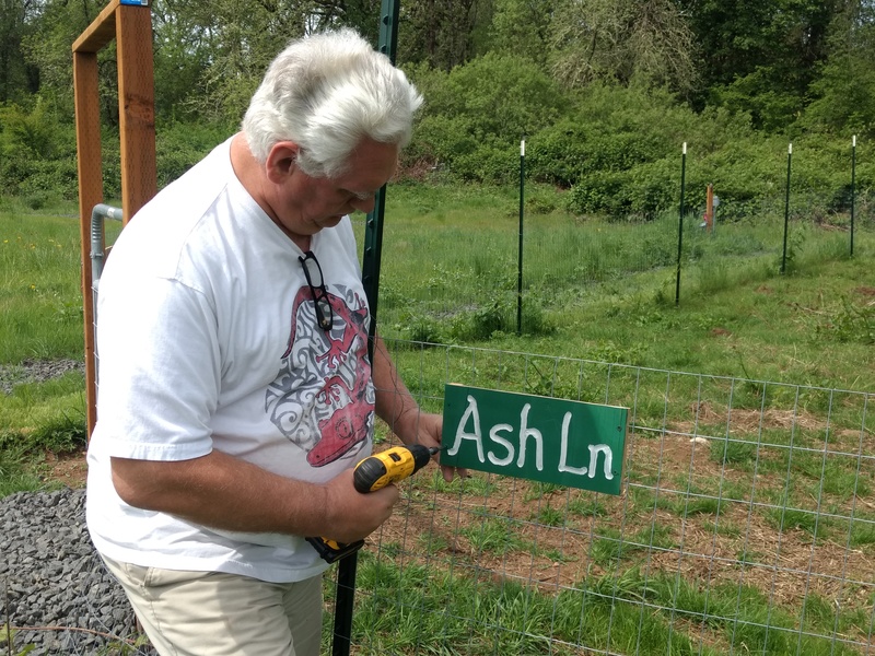 Don attaches the new sign for "Ash Lane" next to the west pasture.