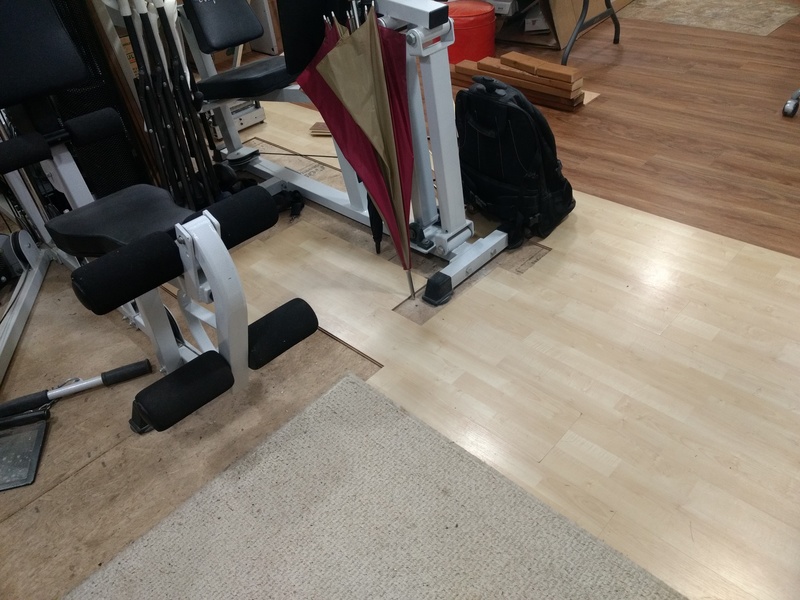 The light (temporary) flooring works its way around the exercise equipment (aka Clothing Rack).