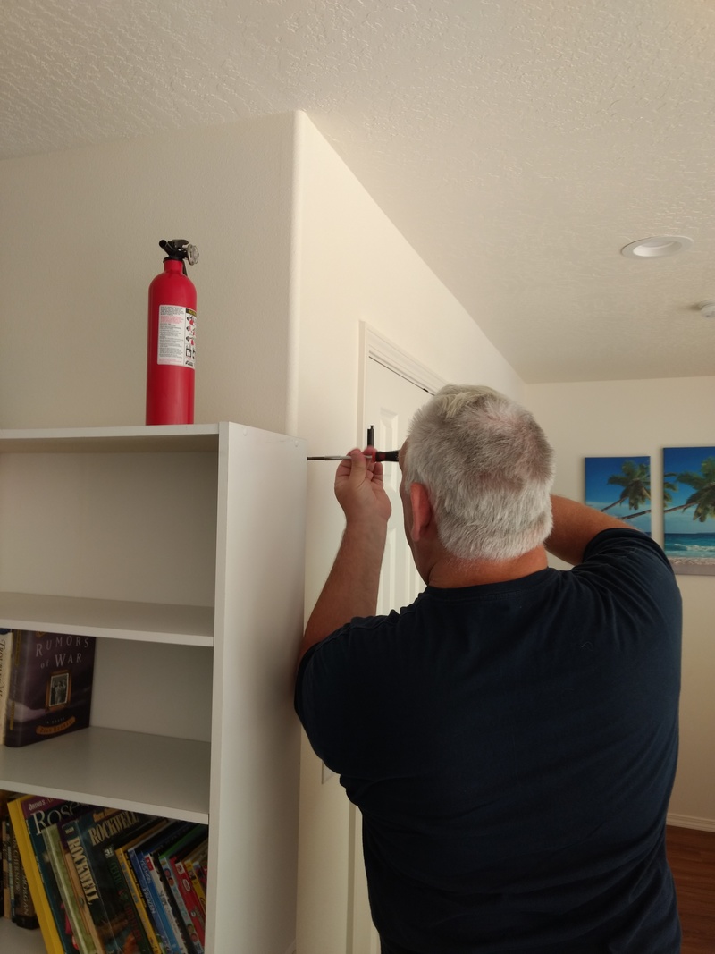 Don installs a fire extinguisher next to Upper Linen.