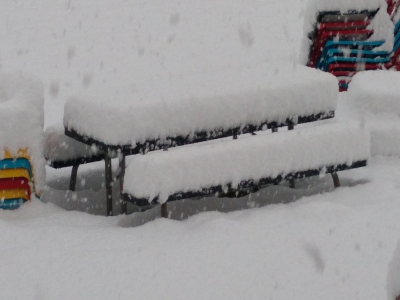Mon 7am: The picnic table is mostly covered. Lots more than 12 inches deep.