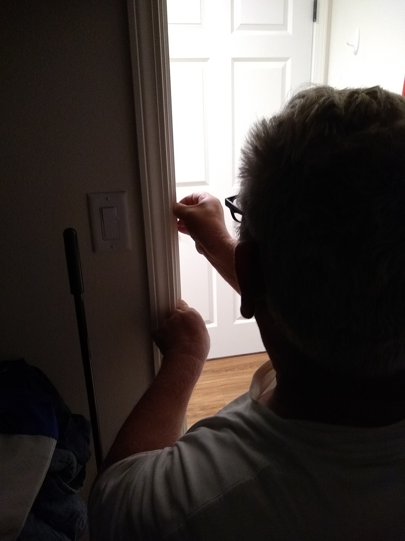 Don installs pilot project weatherstripping on the bedroom door.