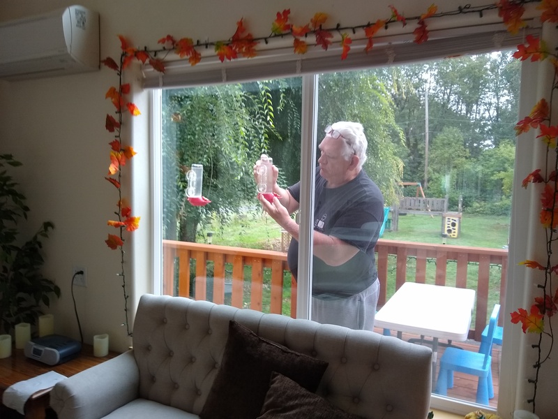 Don is refilling the hummingbird feeder. They seem to be emptying faster.