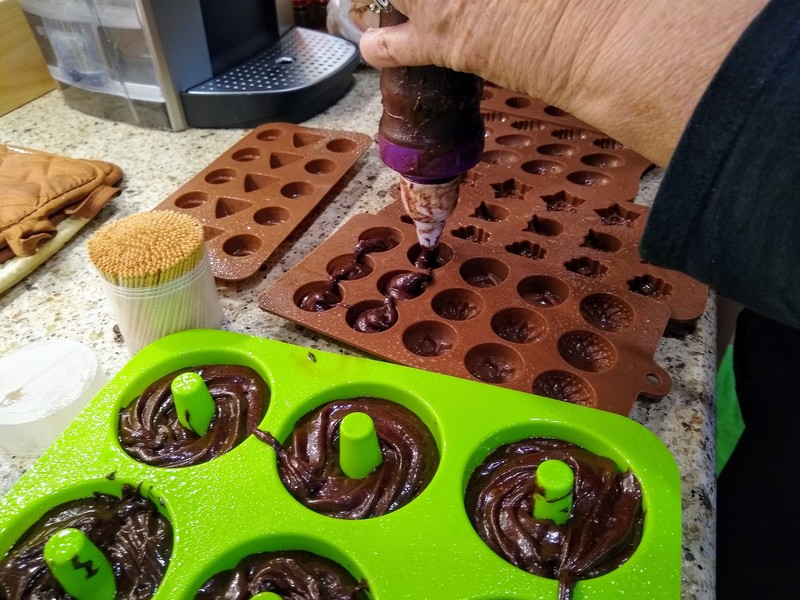 Lois is using the tubes to put brownie batter into the molds.