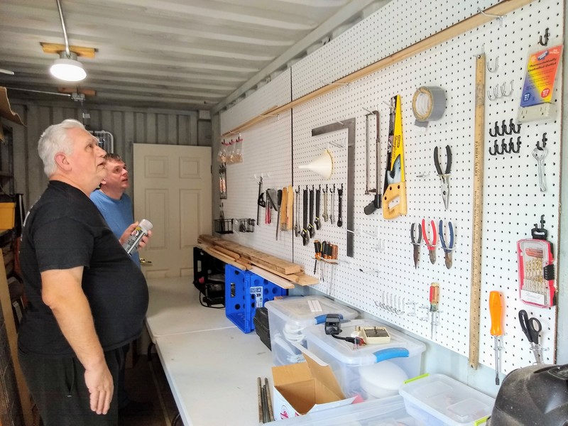 Don and Joseph look at installed pegboard in his container. Loaded with tools.
