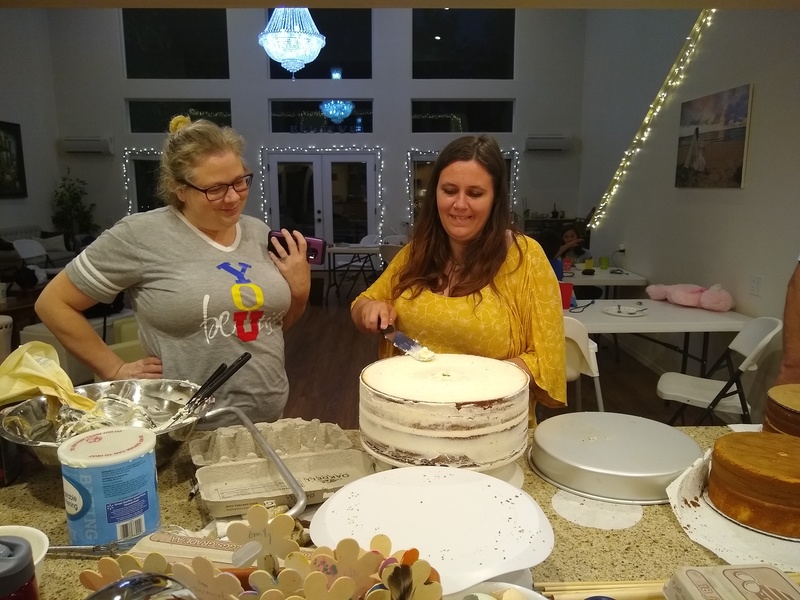 Dina and Larissa are looking at the wedding cake.