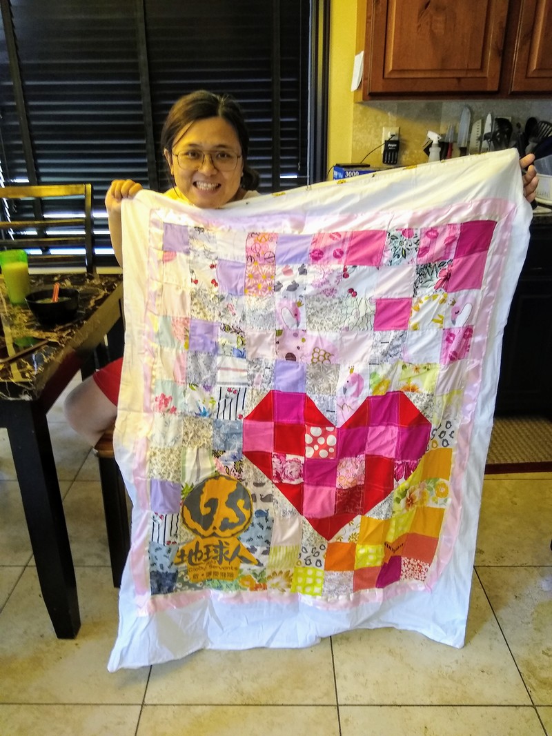Zing Zing shows off a baby quilt that her cousin made for her.