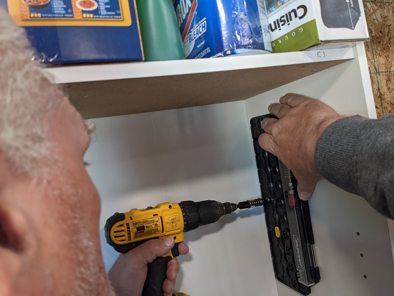 Don drills holes for better shelf spacing in the pantry.