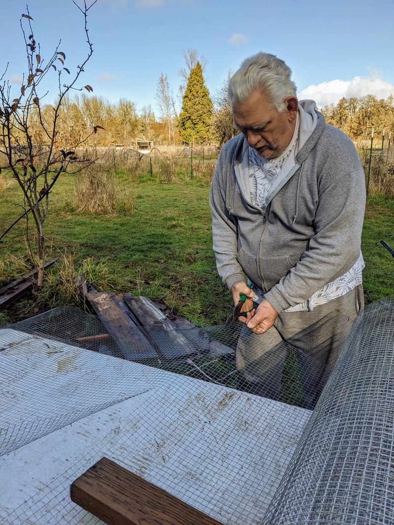 Don cutting the fence mesh before we install them to 2x4s to make a partition between cells.
