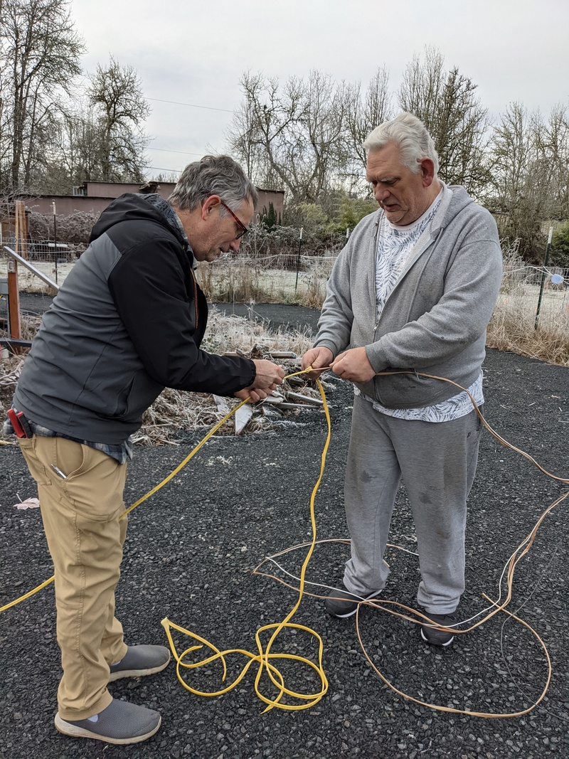 CCon. Jim and Don strip the sheath from 12-2 electrical wire that will be used to energize the electrical panel.