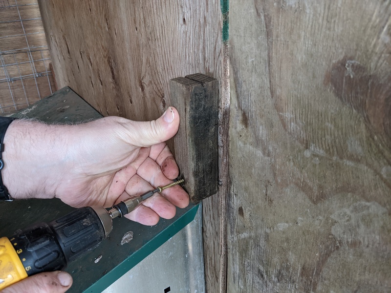 Don screws a latch into place.