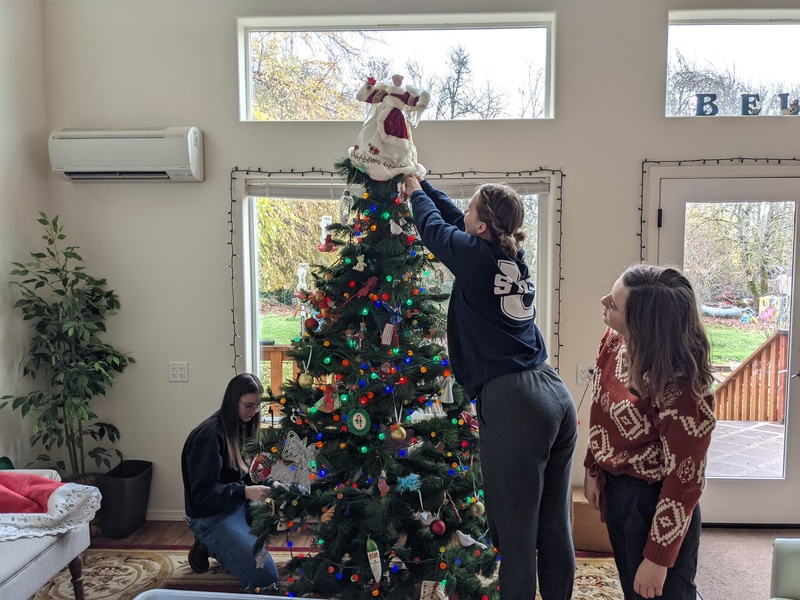 Sister Earl, Sister Hill, and Sister Earl working on the Christmas tree.