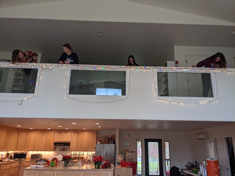 Sister Earl, Sister Hill, Sister Dawson, and Sister Spotten putting up Christmas lights.