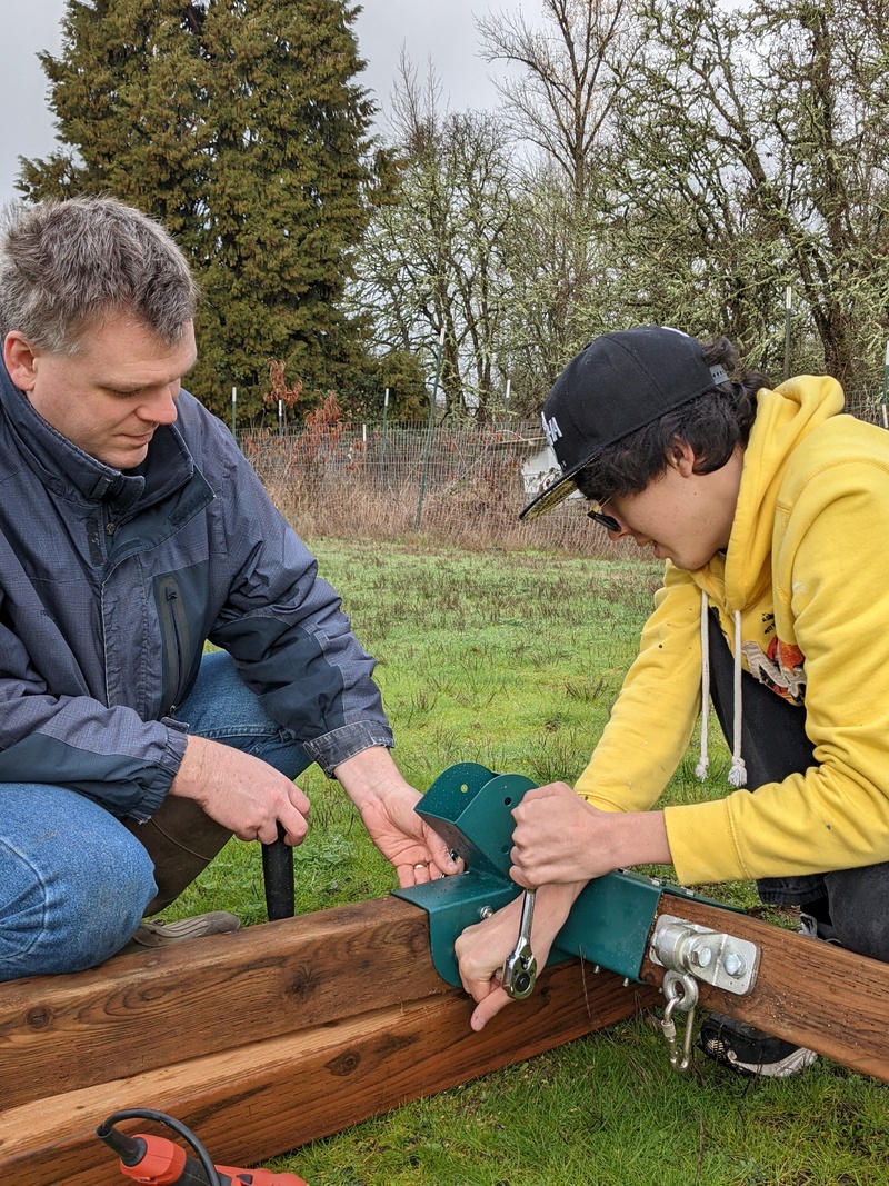 Joseph and Mikey working with a nut and bolt.