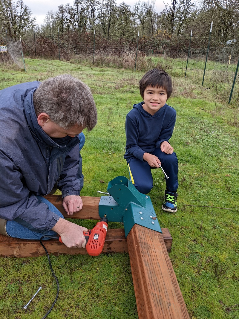 Joseph drills. Kekoa is ready with a bolt for the hole.