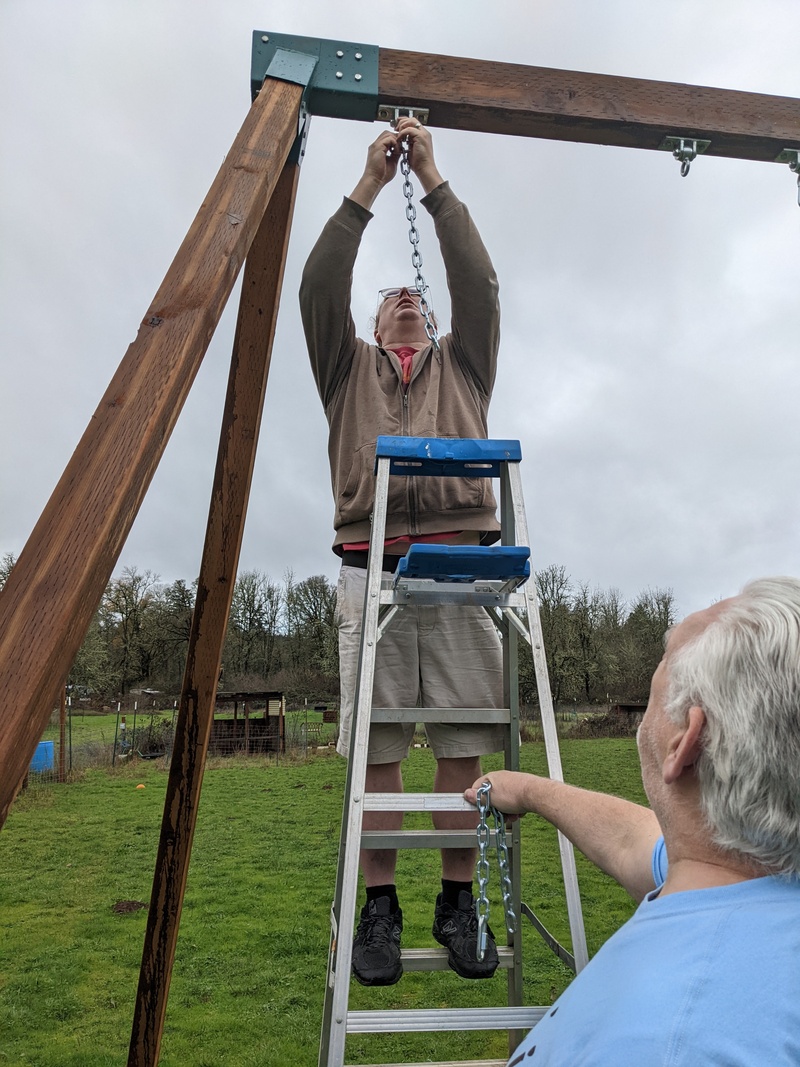 Ben hooking the extension chains to the swings.