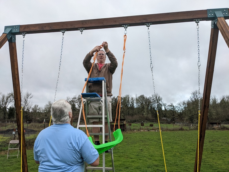 Ben hooking the extension chains to the swings.