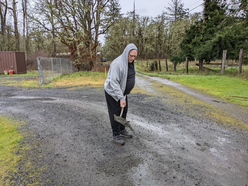Don is shoveling gravel on the road