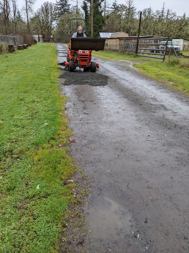 Don is dumping gravel and load is spreading it.