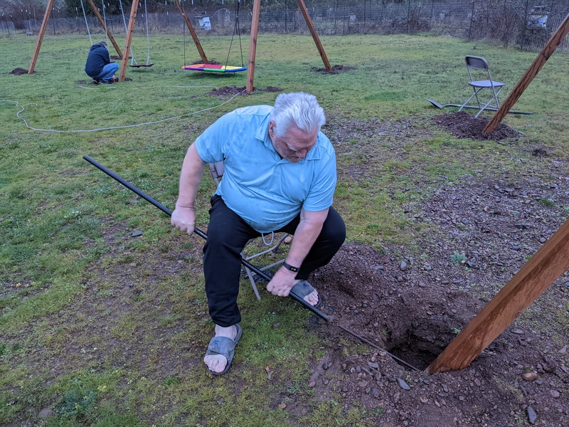 Don is driving rebar into the hole in the post and into the ground.