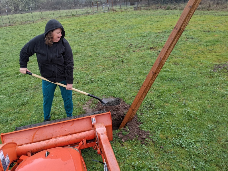 Lois is shoveling more gravel while it rains.