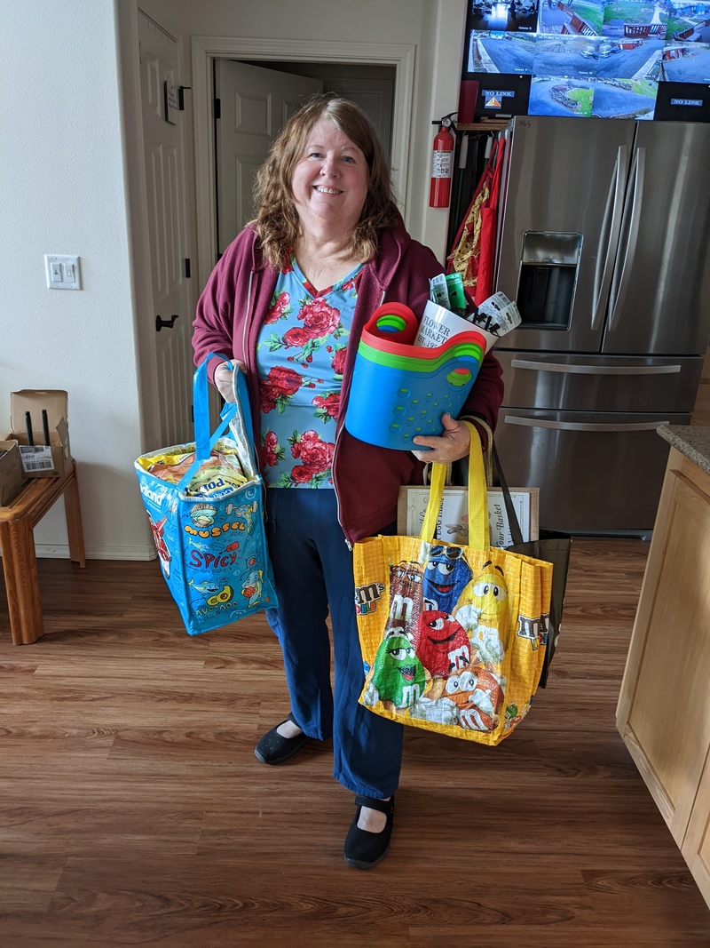 This is how Lois brings in the groceries. Weight training. Three bags, a purse, and a stack of baskets with Easter novelties inside, and Don's new glasses.