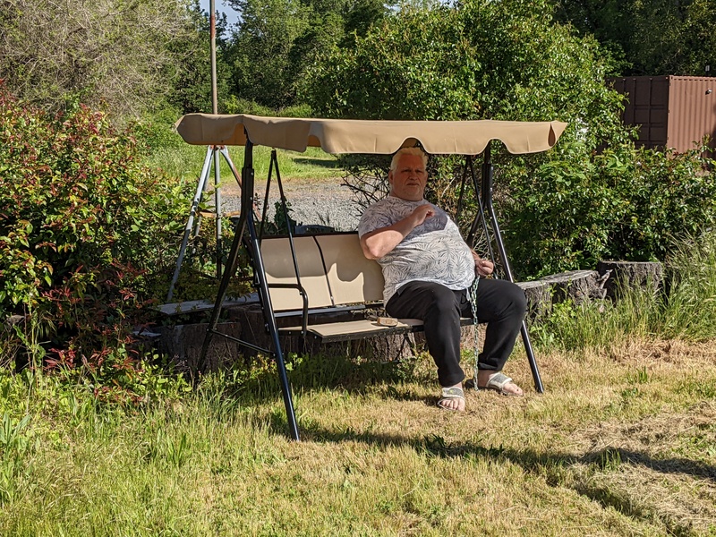 Don repaired the glider swing that kept blowing over. Then he tested it.