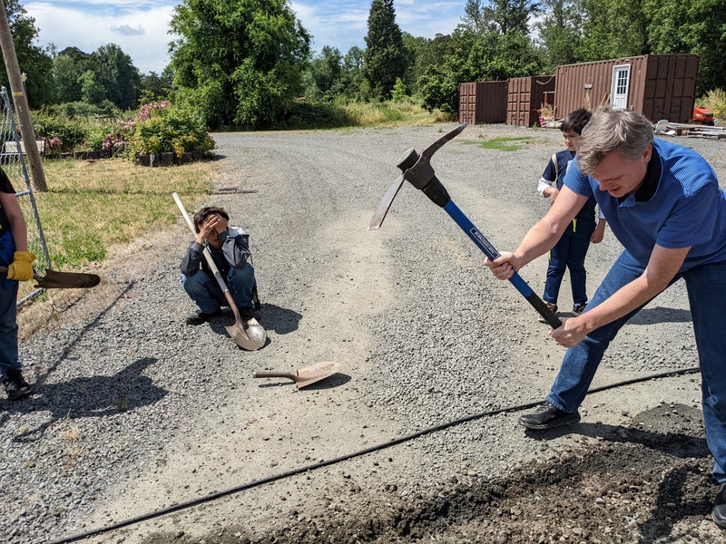 Then grandma got a ramming rod to help break up the gravel. Then Joseph got a pick axe to break up the gravel. His muscles work much better.