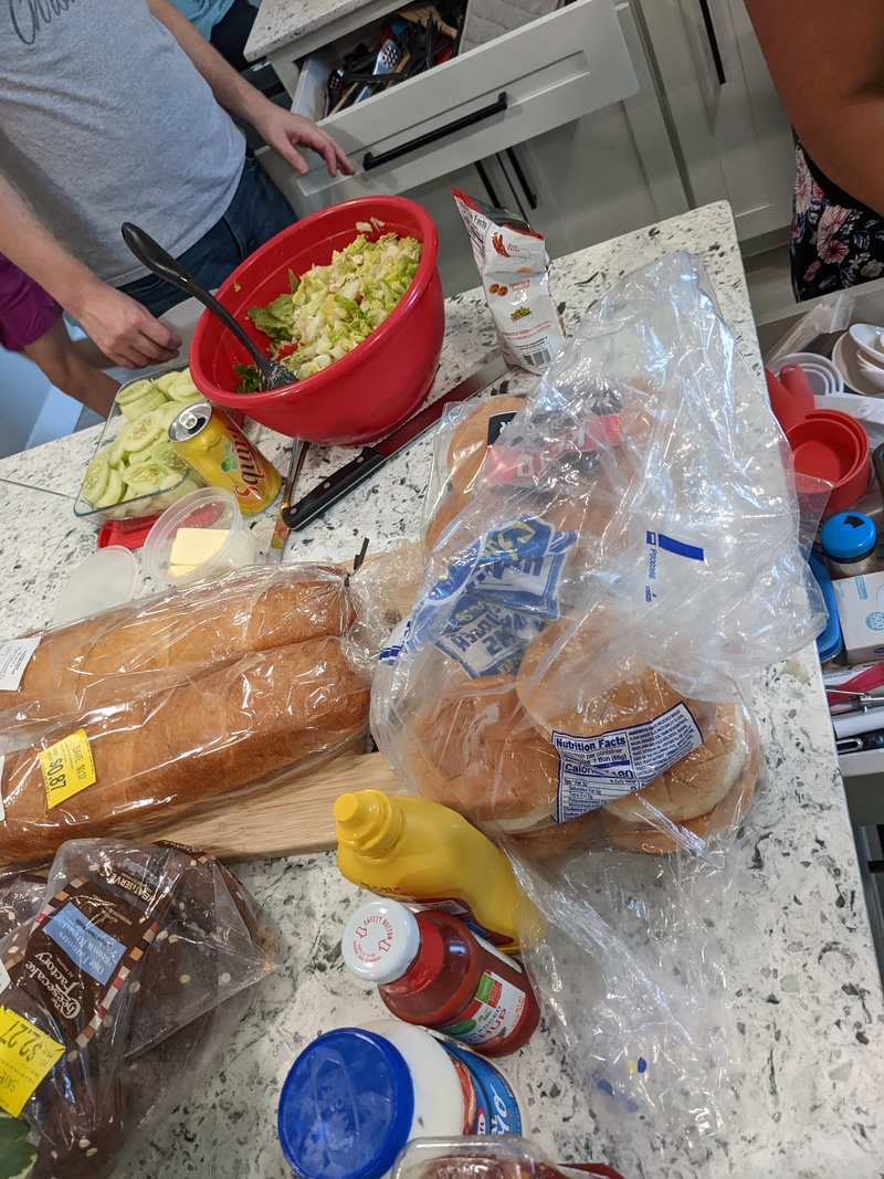 Hamburger condiments buns, bread, salad, and cucumbers.