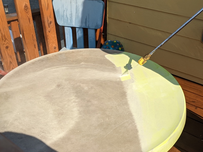Lois powerwashing the kids table. She thought it had faded to brown.