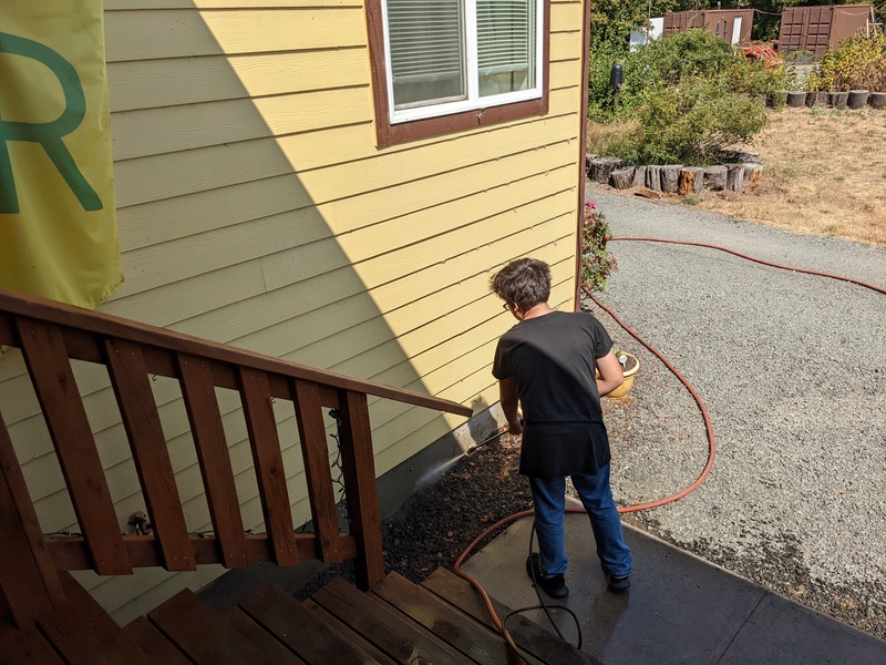 Kili powerwashing the house and front cement.