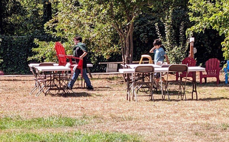 Timmy and Kekoa setting up chairs in the picnic area.