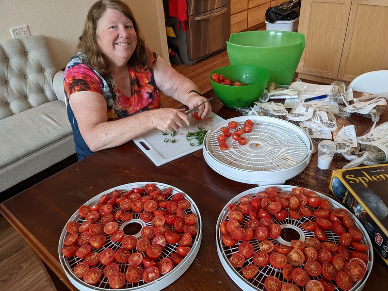 Lois cutting the red cherry tomatoes in half.