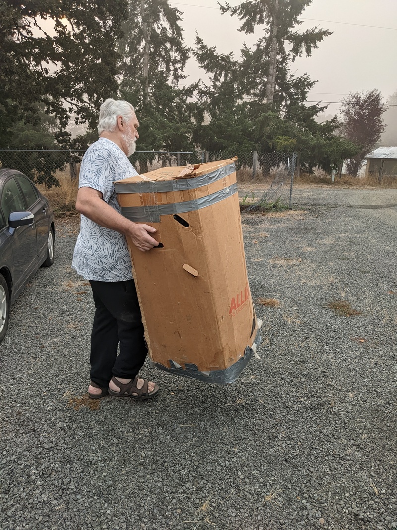 Don carrying the Christmas tree box to house so we can have more room in Lois's container.