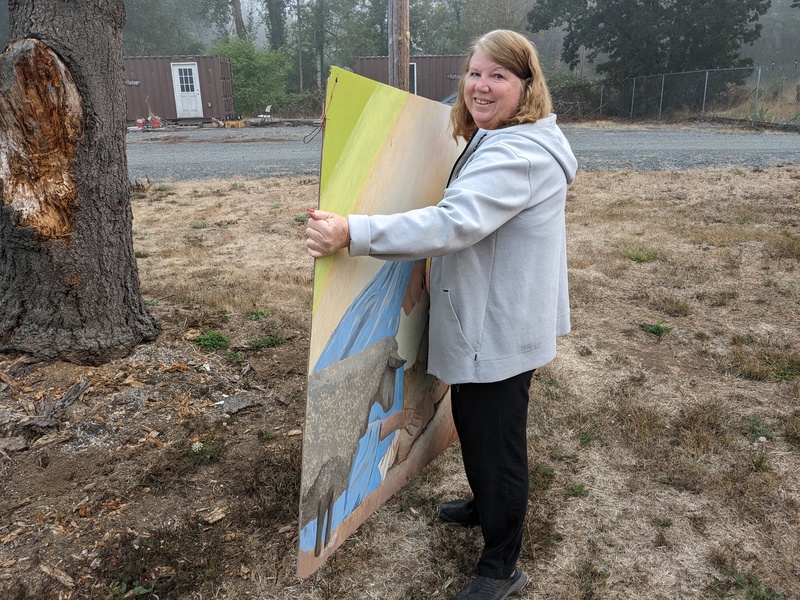 Lois carrying the Christmas painting to house so we can have more room in Lois's container.