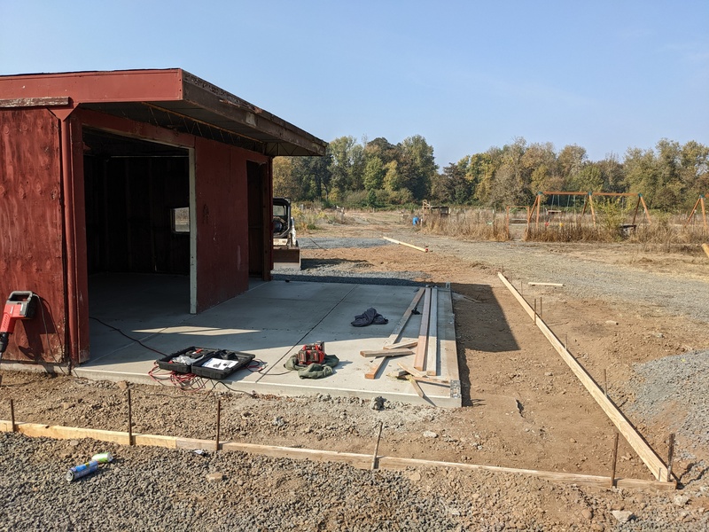 Sidewalk around the red shed is framed.