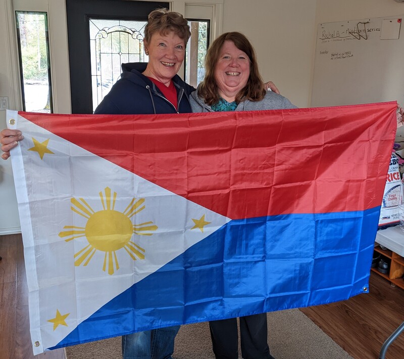 Laura and Laura holding up the Philippines flag.