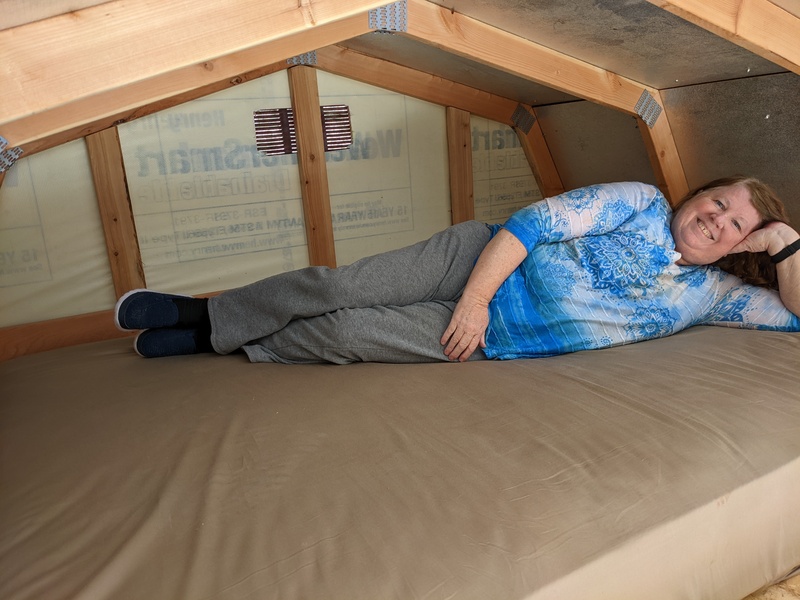 Lois lying on the queen mattress in the loft.