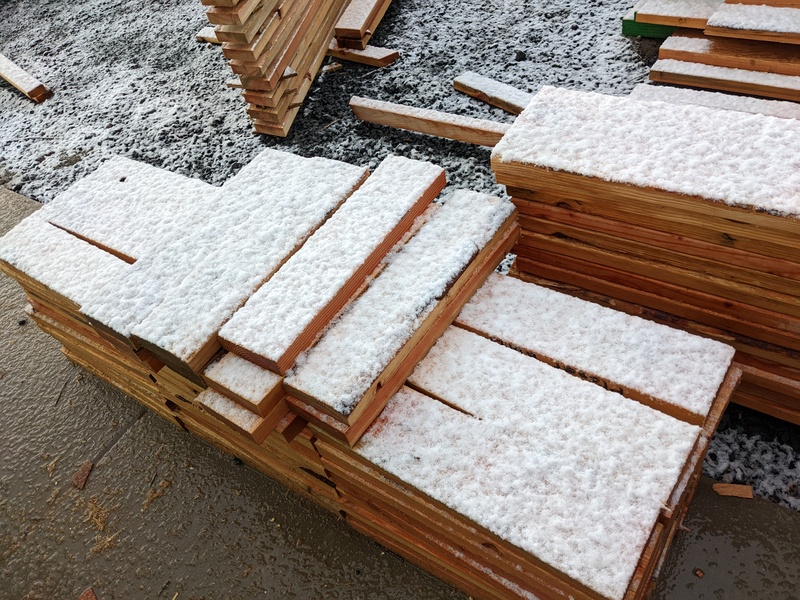 Snow covering the wood piles.