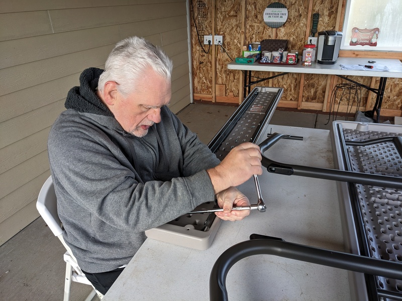 Lois and Don assemble picnic tables.