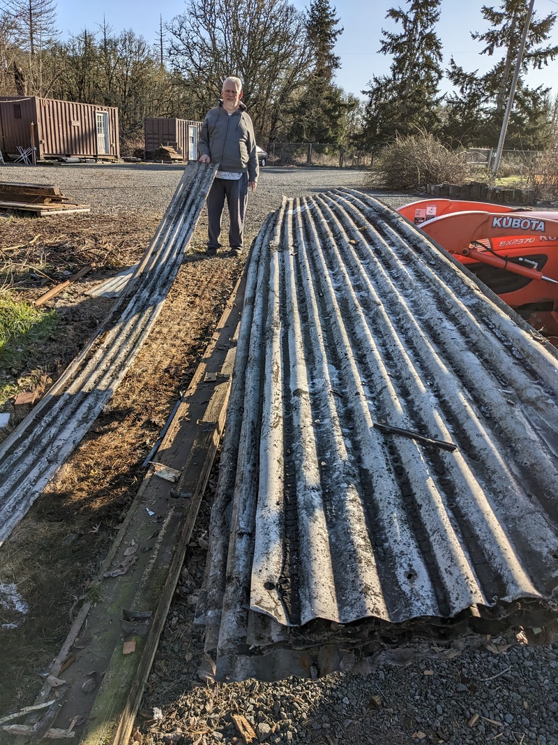 Don loads the old roofing material from the red shed onto the tractor.