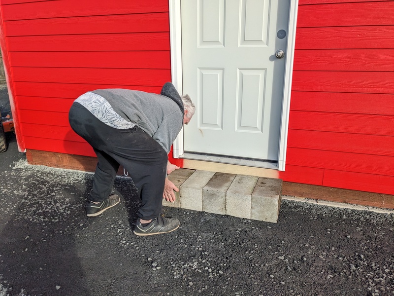 Don putting brick for a step at the back of B 3.