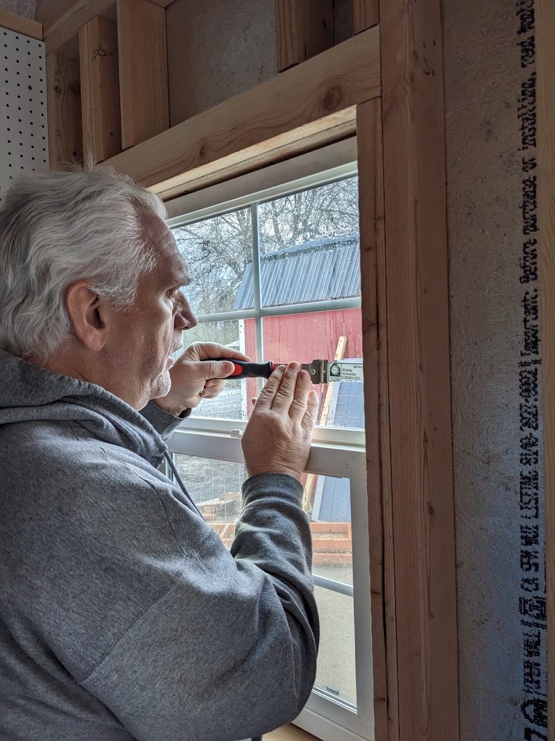 Don scraping labels off windows.