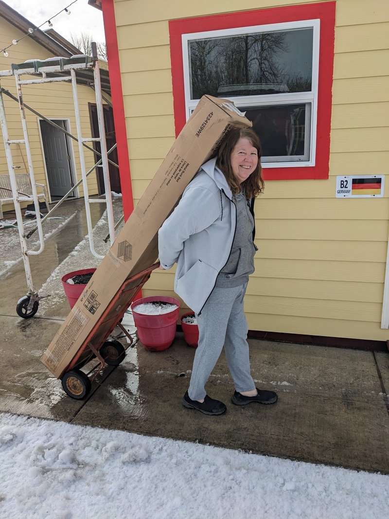 B3: Lois hauls the fifth bunk bed from its storage location to its final destination.