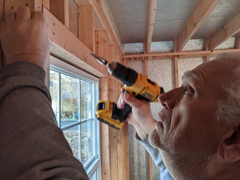 Don installing curtain rods in B7.