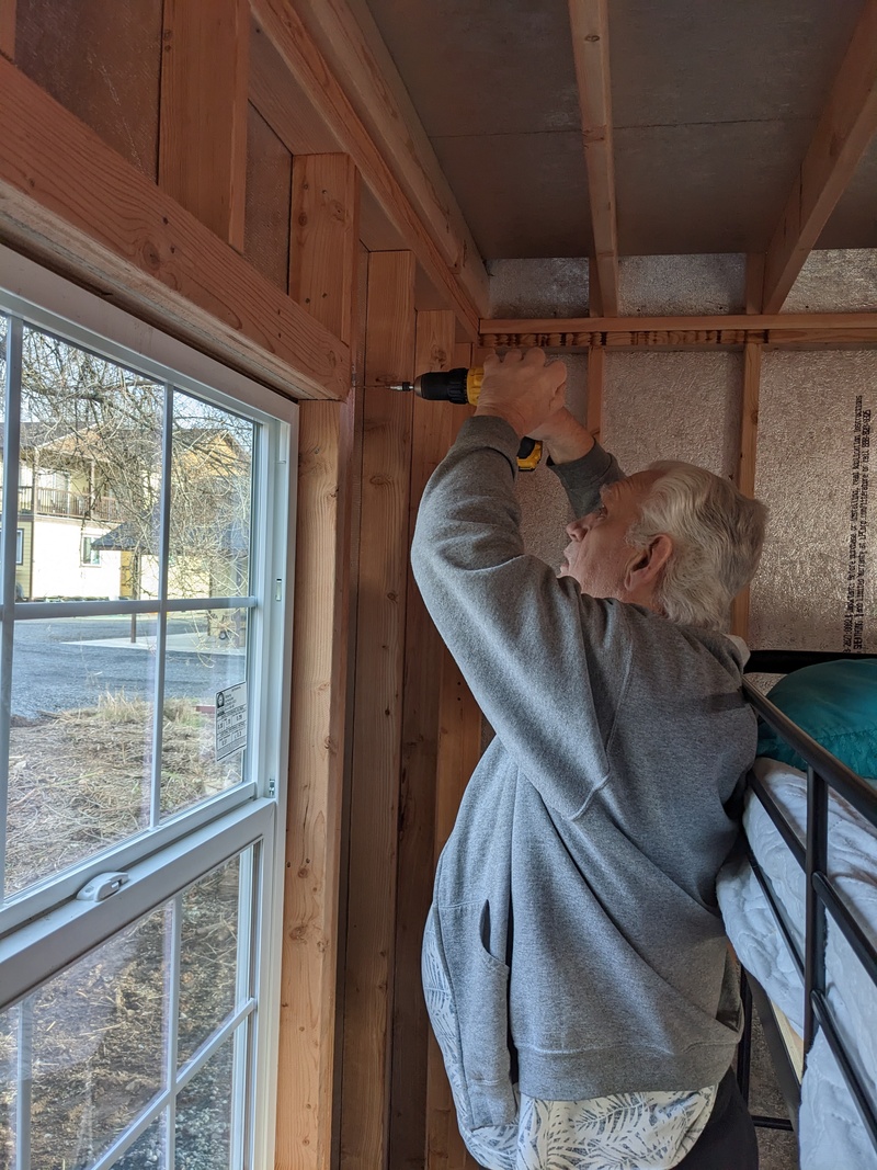 Don installing curtain rods in B7.