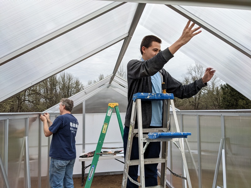 Joseph and Alex putting in roofing panels.