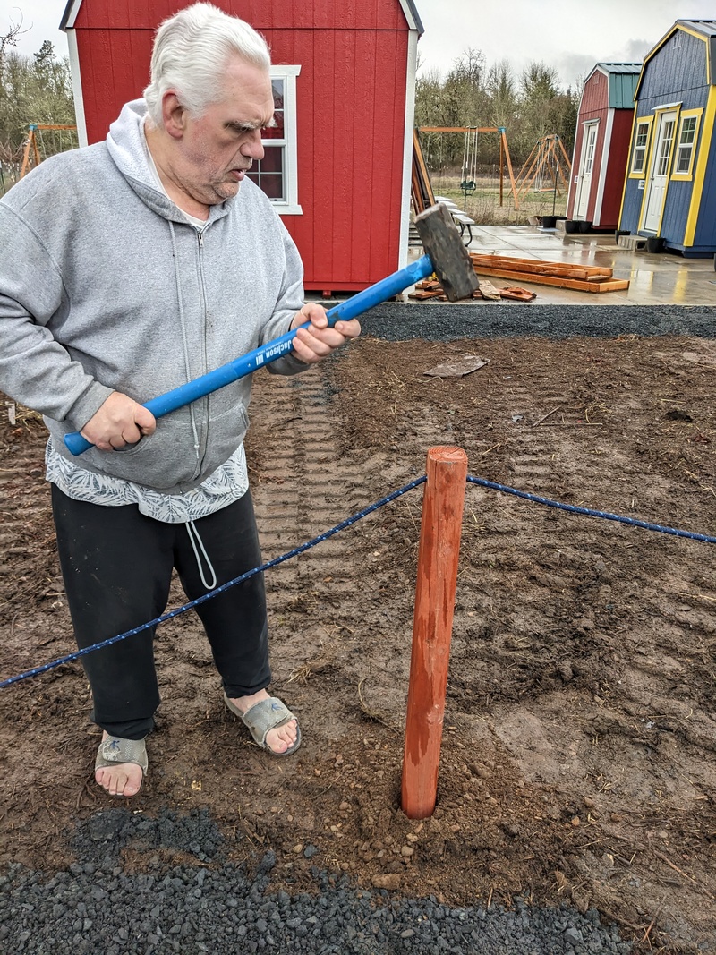 Don pounding in fence posts.