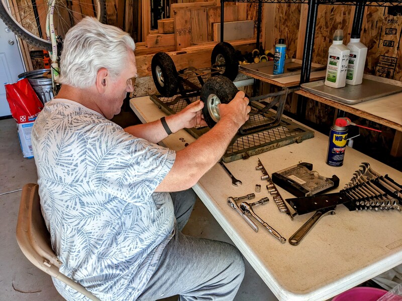 Don repairs a wagon wheel.