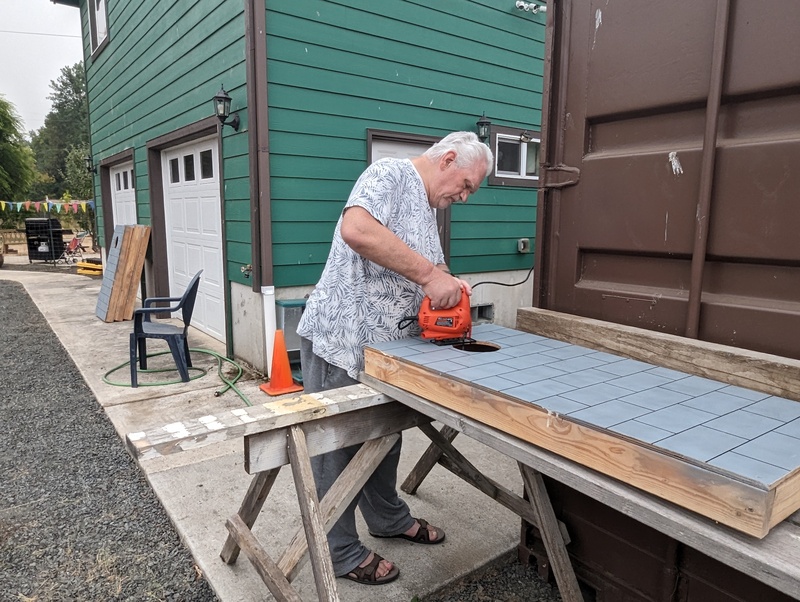 Don cuts holes in the corn hole targets.