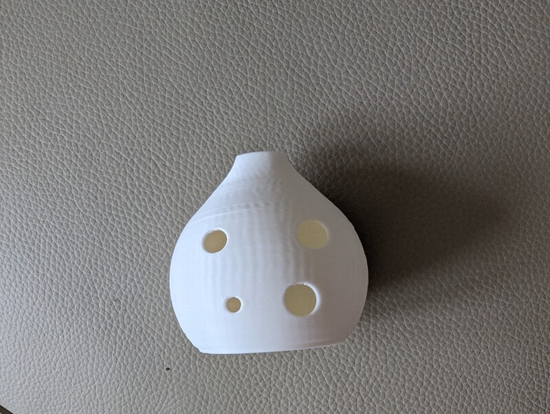 White ocarina. Four holes. You can play a whole octave.